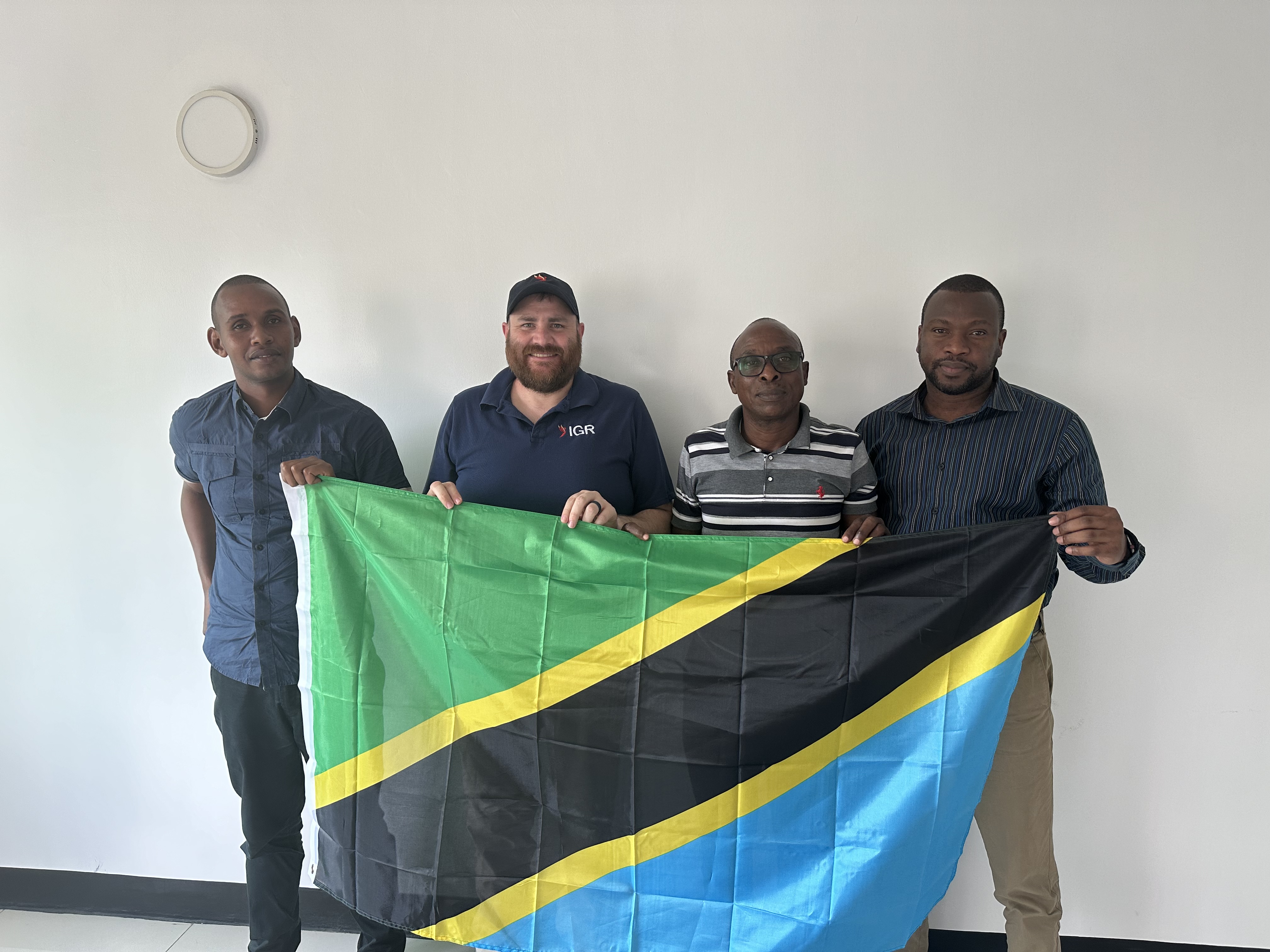 IGR staff with members of the Tanzania Police Force holding the Tanzanian flag