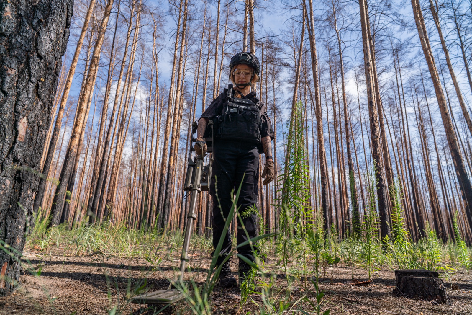 An IGR deminer conducting manual clearance in a forested area