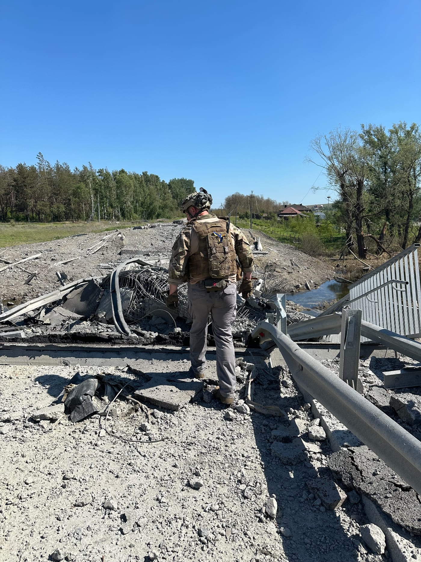 An IGR specialist assessing a bridge destroyed by conflict
