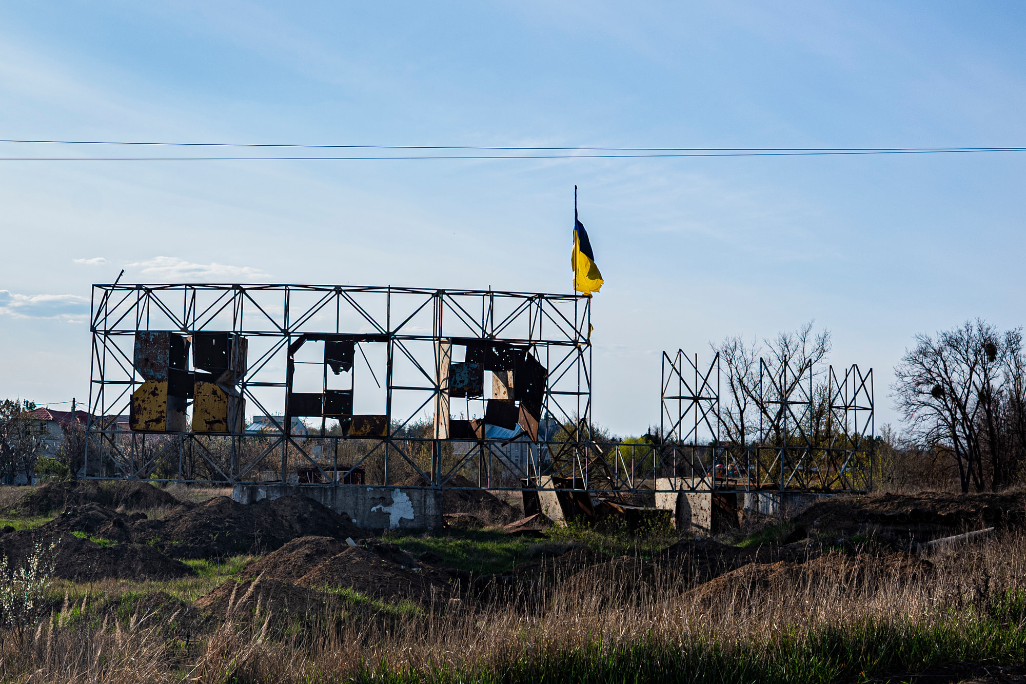 A Ukrainian flag flying above a war-damaged structure in Kharkiv Oblast