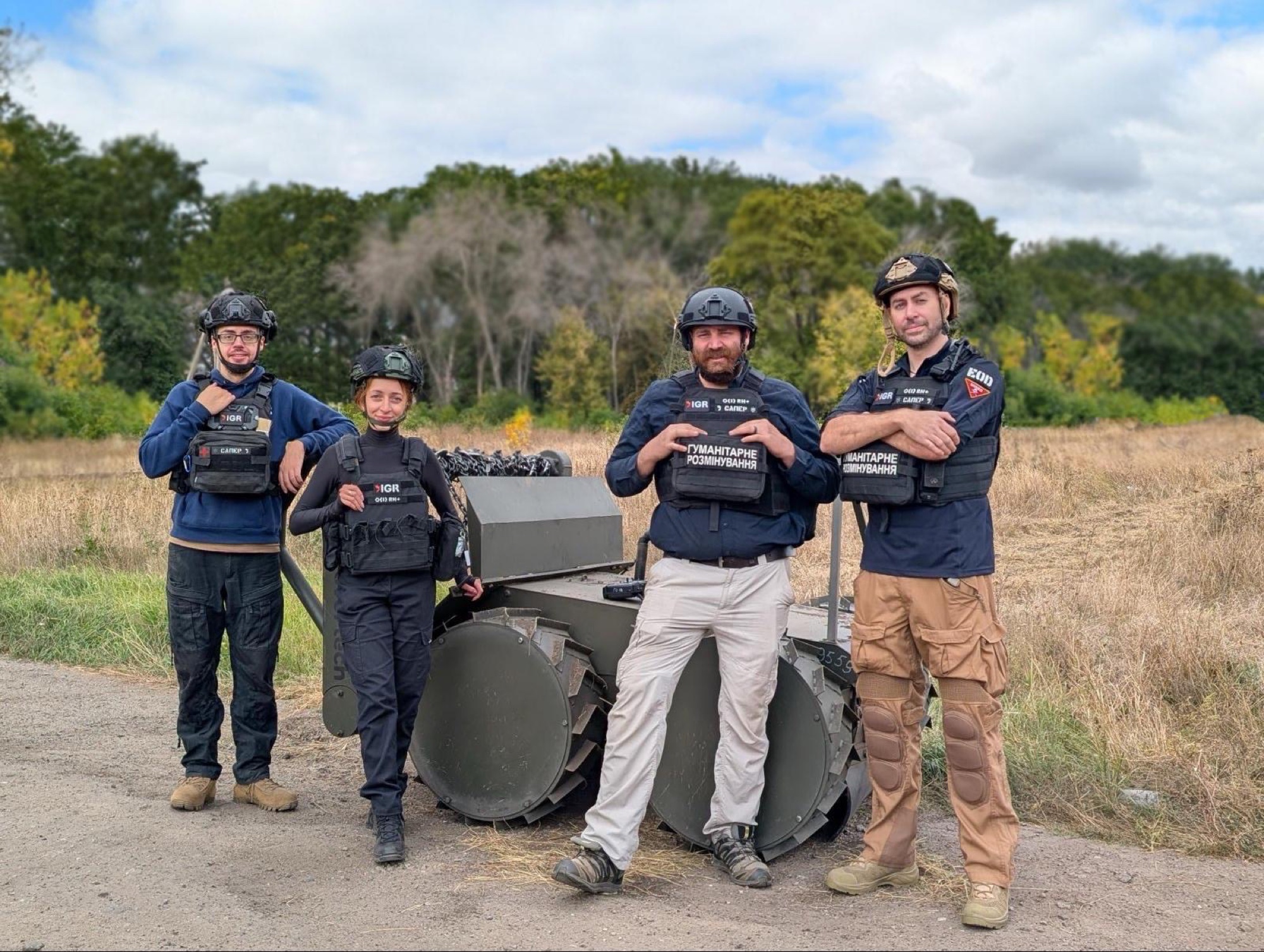 IGR personnel beside mechanical demining equipment in Ukraine
